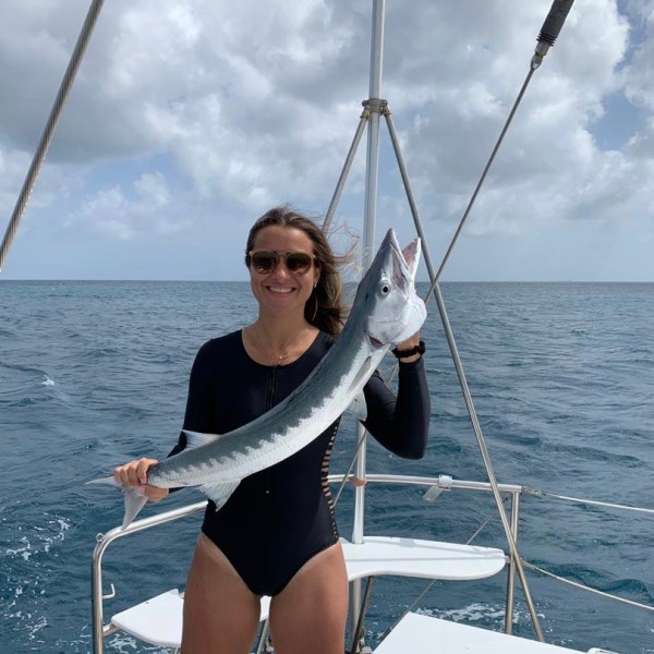 a woman standing next to a body of water