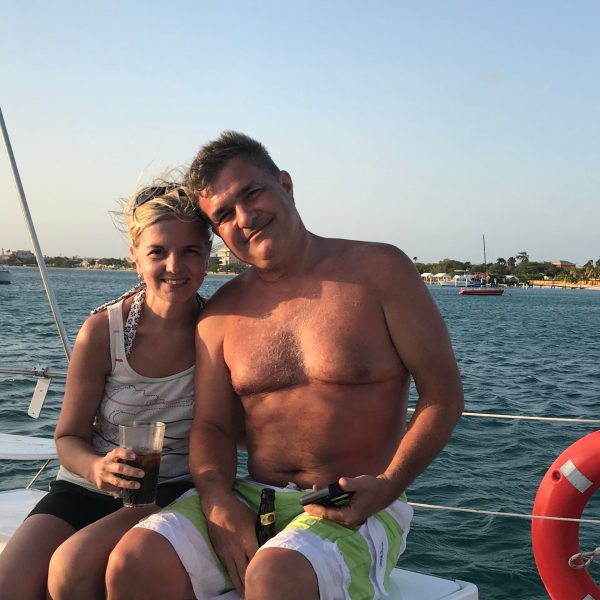 a man and woman sitting next to a body of water