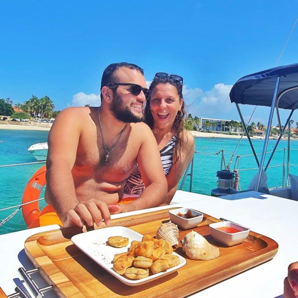 a person sitting at a table with food and water